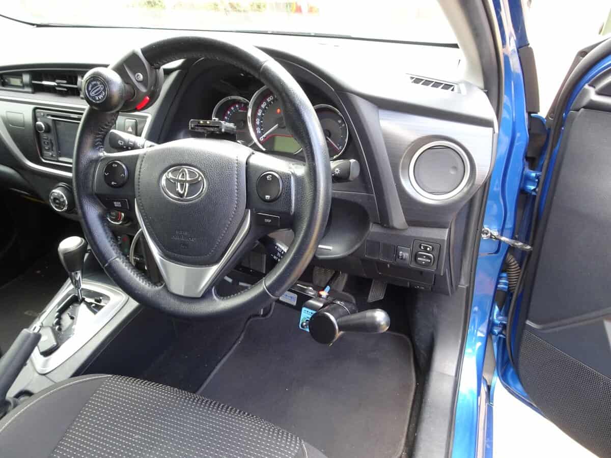 Inside a car, highlighting the steering wheel and dashboard, essential for evaluations related to driving disabilities and conditions.