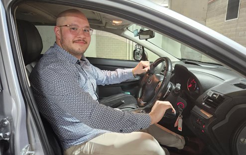 older male with leg amputation driving with vehicle hand controls