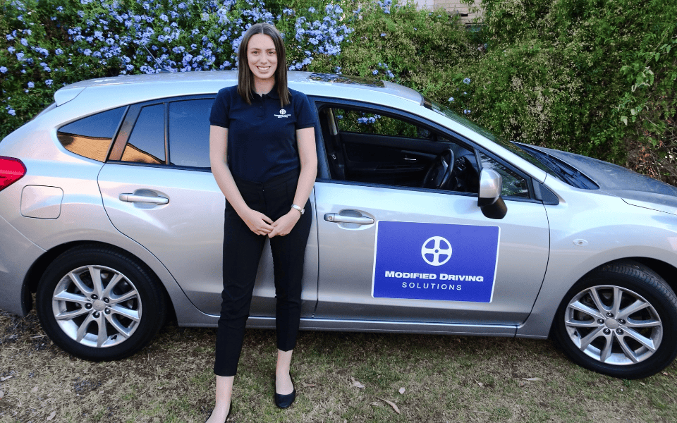 image-1 Occupational therapist standing beside a Modified Driving Solutions vehicle, ready to conduct a post-stroke driving assessment.